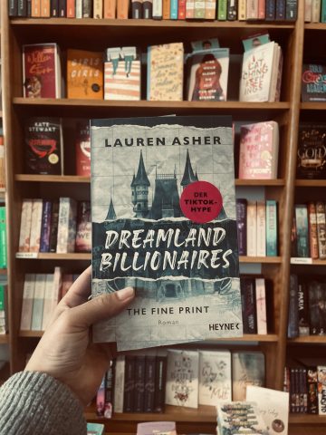 Fridaygirl hält das Buch Dreamland Billionaires - The Fine Print in der Hand