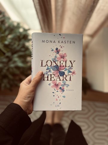 fridaygirl hält das Buch Lonely Heart in der Hand